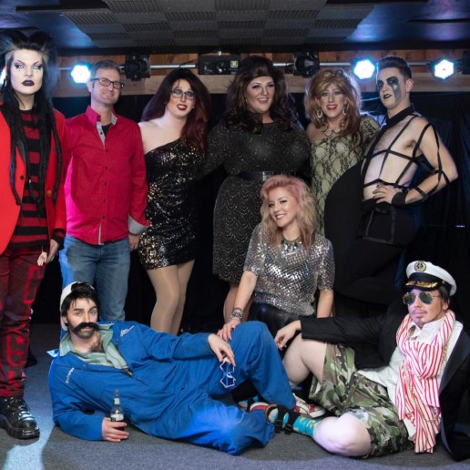 A group of people in spooky and glamorous costumes.